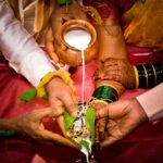 Close-up of a traditional Indian wedding ritual involving milk pouring on hands, depicting cultural values and symbolism.